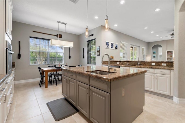 kitchen featuring a kitchen island with sink, a healthy amount of sunlight, sink, and pendant lighting