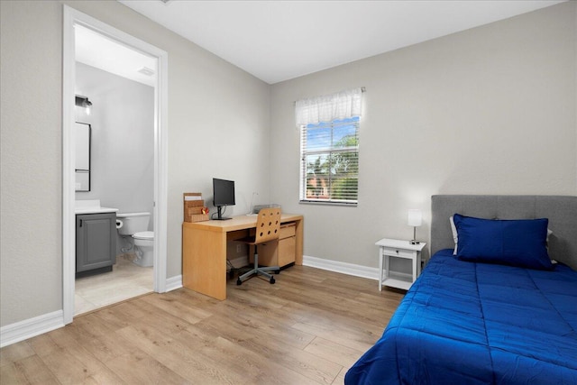 bedroom with ensuite bathroom and hardwood / wood-style floors