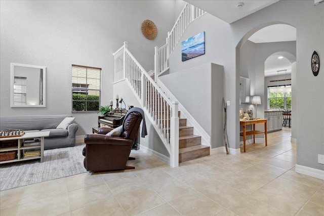 staircase featuring a towering ceiling and tile patterned flooring