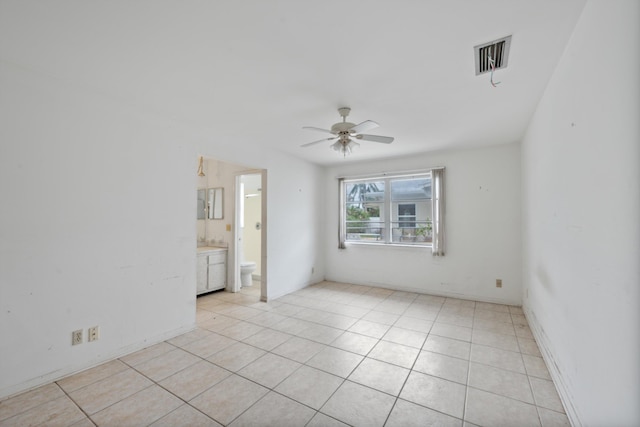 empty room with ceiling fan and light tile patterned floors