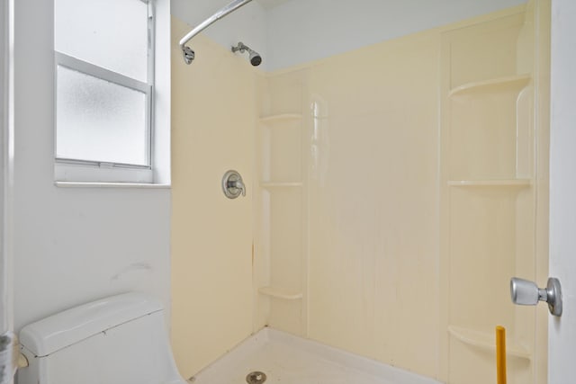 bathroom featuring walk in shower and toilet