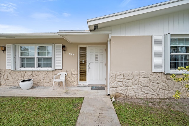 view of exterior entry with a yard