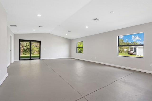 spare room featuring lofted ceiling and concrete floors