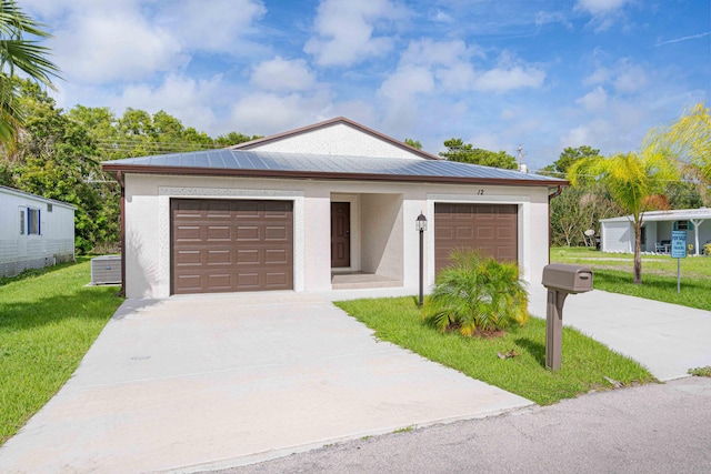 view of front of home featuring a garage, cooling unit, and a front lawn