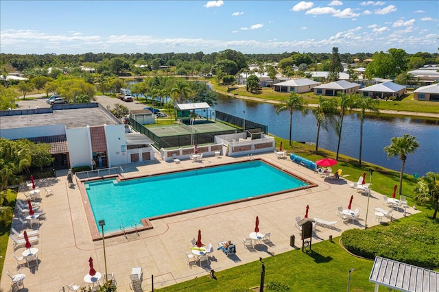 view of swimming pool featuring a water view and a patio