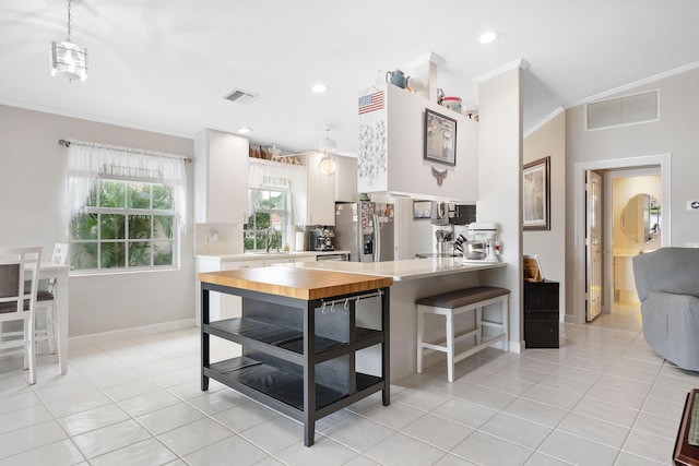 7770 SE Spicewood Cir, Hobe Sound, FL 33455 - kitchen featuring light countertops, stainless steel fridge, ornamental molding, a sink, and light tile patterned flooring