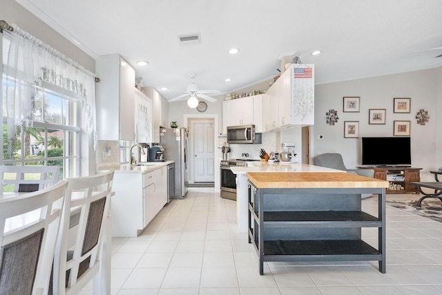 7770 SE Spicewood Cir, Hobe Sound, FL 33455 - kitchen featuring appliances with stainless steel finishes, light countertops, white cabinets, crown molding, and recessed lighting