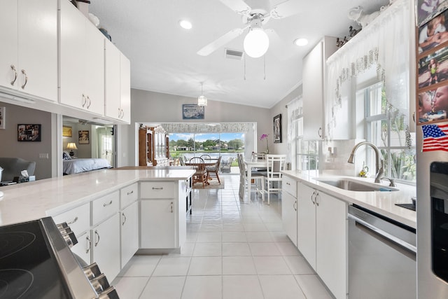 kitchen with sink, light tile patterned floors, white cabinets, dishwasher, and vaulted ceiling