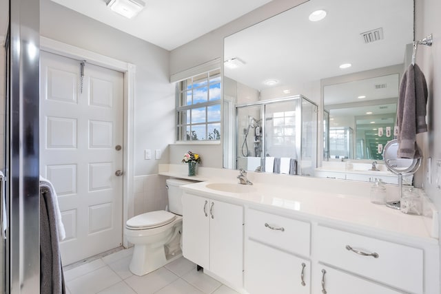 bathroom featuring vanity, walk in shower, tile patterned flooring, and toilet