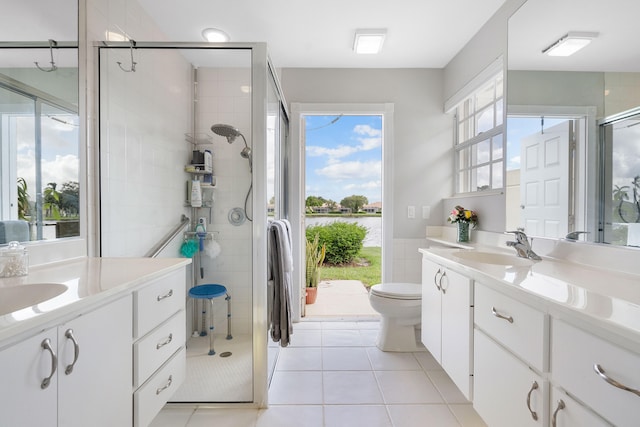 bathroom featuring walk in shower, tile patterned flooring, vanity, and toilet