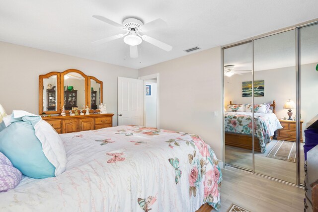 7770 SE Spicewood Cir, Hobe Sound, FL 33455 - bedroom featuring a closet, a ceiling fan, and light wood-style flooring