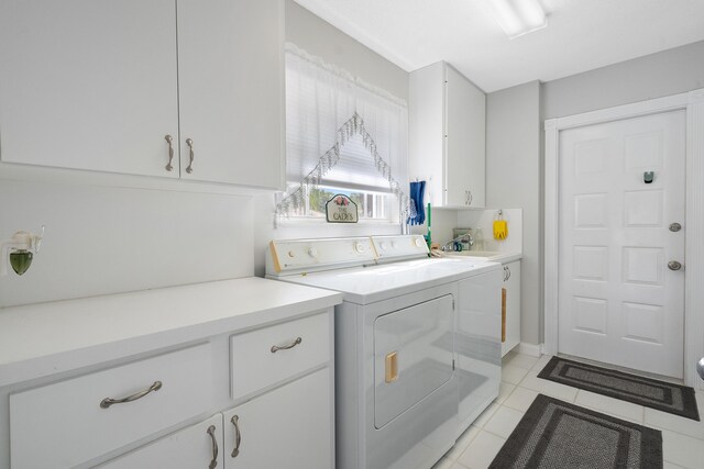 7770 SE Spicewood Cir, Hobe Sound, FL 33455 - laundry area with cabinet space, washer and clothes dryer, and light tile patterned floors