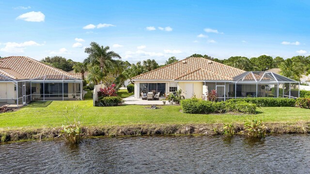 7770 SE Spicewood Cir, Hobe Sound, FL 33455 - rear view of property with a water view, a lawn, and a tiled roof