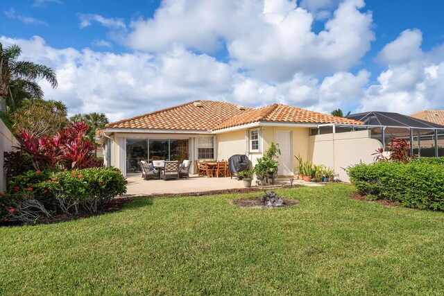 7770 SE Spicewood Cir, Hobe Sound, FL 33455 - back of house with a tiled roof, stucco siding, a lawn, a patio area, and an outdoor hangout area