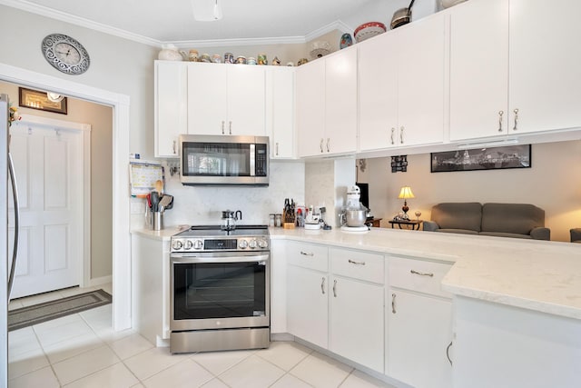 7770 SE Spicewood Cir, Hobe Sound, FL 33455 - kitchen featuring stainless steel appliances, white cabinetry, ornamental molding, light tile patterned flooring, and backsplash
