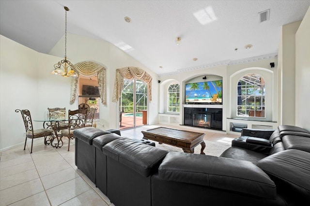 living room with a healthy amount of sunlight, lofted ceiling, a textured ceiling, and light tile patterned floors