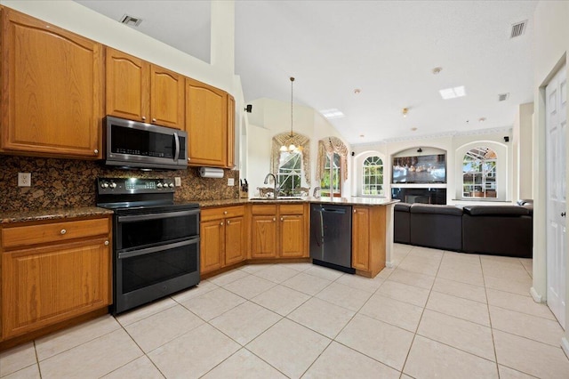 kitchen with sink, backsplash, dark stone counters, vaulted ceiling, and appliances with stainless steel finishes