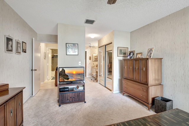 carpeted living room featuring a textured ceiling and ceiling fan