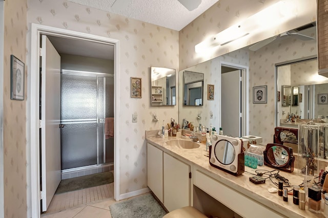 bathroom featuring vanity, a textured ceiling, tile patterned floors, and a shower with door