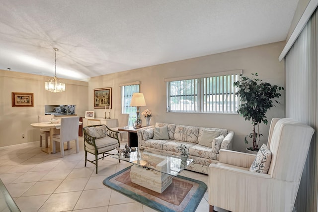 tiled living room featuring a chandelier and a textured ceiling