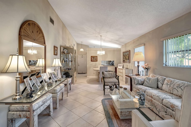 living room with light tile patterned flooring, a chandelier, a textured ceiling, and vaulted ceiling