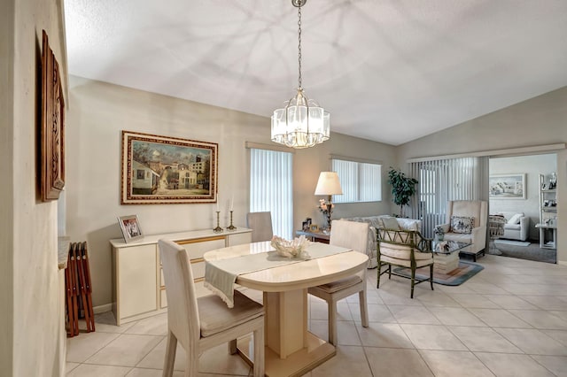 dining room with an inviting chandelier, vaulted ceiling, and light tile patterned floors