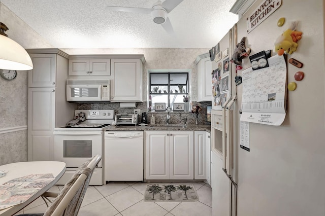 kitchen with light tile patterned flooring, a textured ceiling, sink, white appliances, and ceiling fan