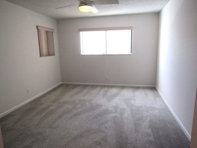 carpeted empty room featuring ceiling fan and a textured ceiling