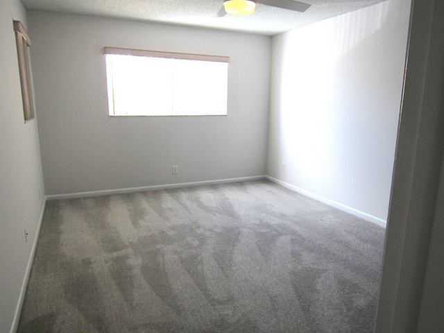 spare room with ceiling fan, a textured ceiling, and carpet flooring