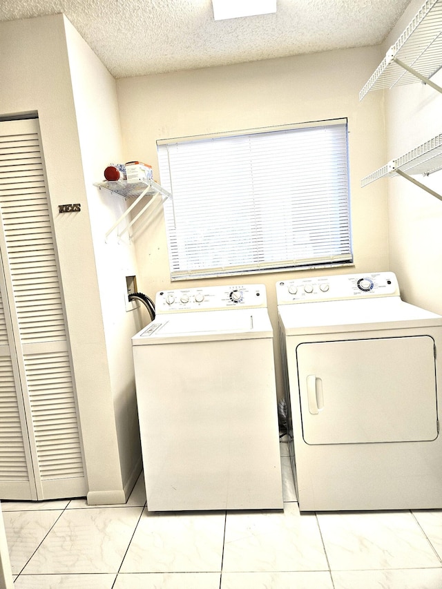 washroom with washer and dryer and a textured ceiling