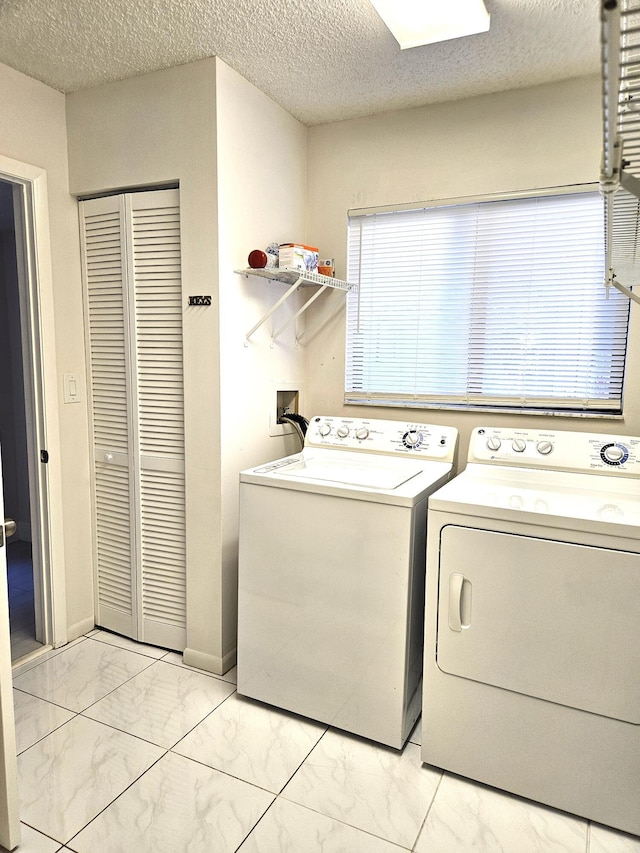 laundry room featuring separate washer and dryer and a textured ceiling