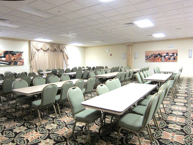 carpeted dining room with a drop ceiling