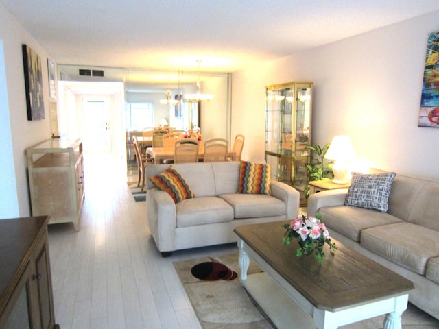 living room featuring a chandelier and light wood-type flooring