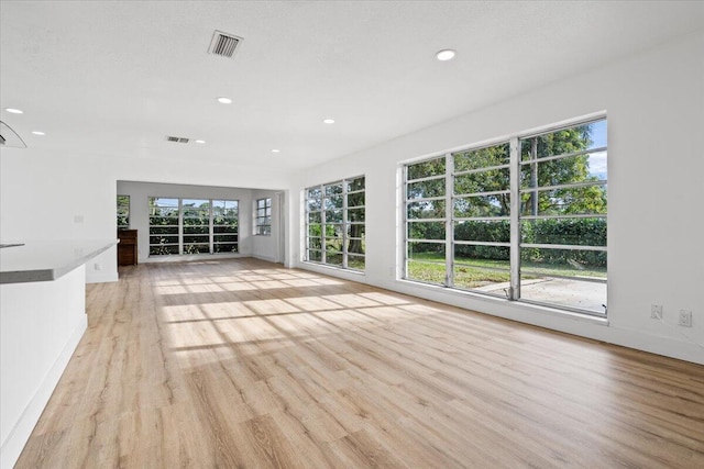 unfurnished living room featuring light hardwood / wood-style floors and plenty of natural light