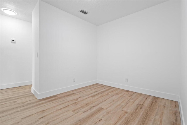 unfurnished room featuring light hardwood / wood-style floors and a textured ceiling