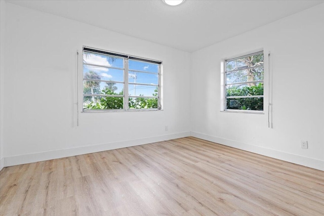 empty room with a wealth of natural light and light hardwood / wood-style floors