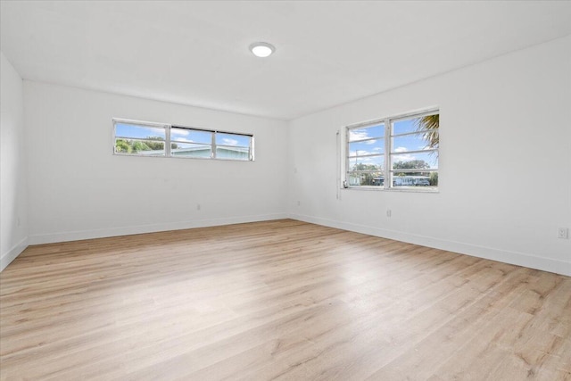 empty room featuring a wealth of natural light and light hardwood / wood-style flooring