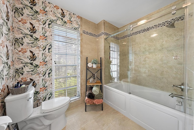 bathroom featuring bath / shower combo with glass door, a wealth of natural light, toilet, and tile patterned flooring