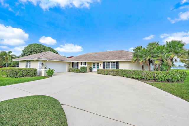 ranch-style home featuring a garage and a front yard