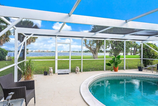 view of swimming pool featuring glass enclosure, a patio area, a water view, and a lawn