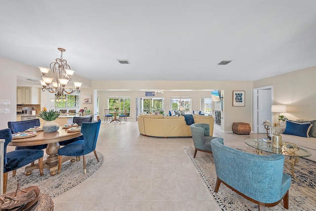 living room with light tile patterned flooring and a notable chandelier