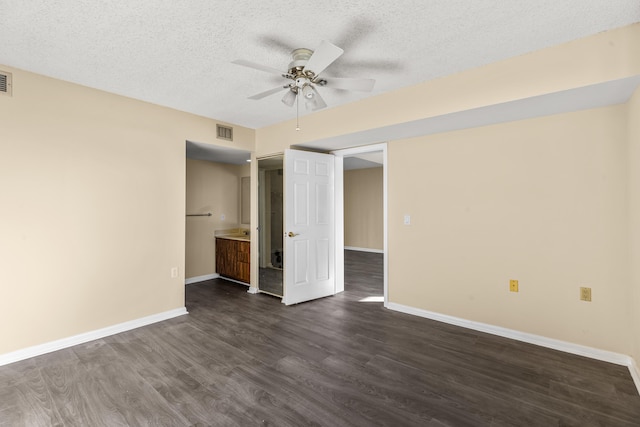 unfurnished bedroom with dark wood-type flooring, ceiling fan, a textured ceiling, and connected bathroom