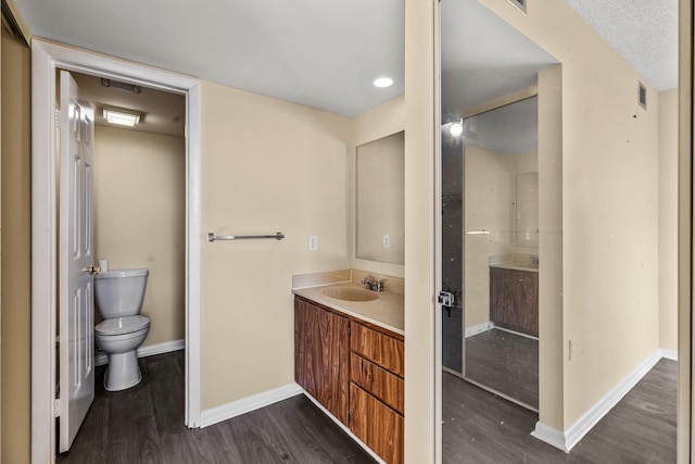 bathroom with hardwood / wood-style floors, vanity, and toilet