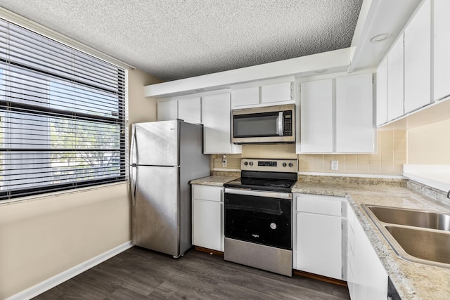 kitchen with white cabinetry, sink, appliances with stainless steel finishes, dark hardwood / wood-style floors, and a textured ceiling