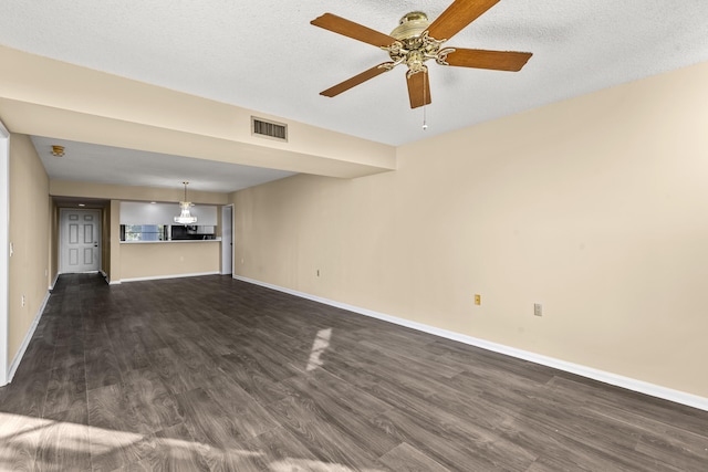 unfurnished living room featuring ceiling fan, dark hardwood / wood-style floors, and a textured ceiling