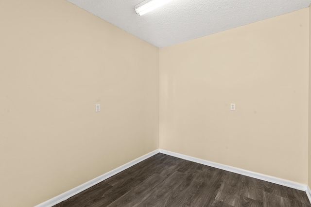 empty room featuring dark hardwood / wood-style flooring and a textured ceiling