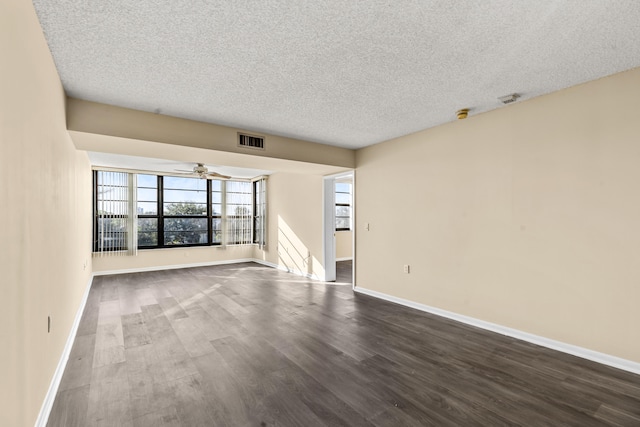 unfurnished room featuring a textured ceiling, dark hardwood / wood-style floors, and ceiling fan