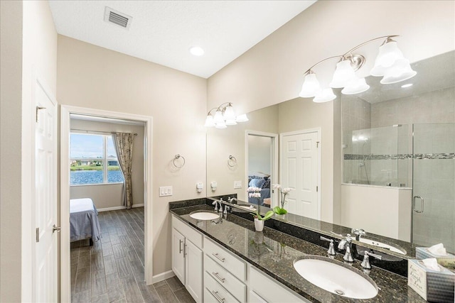 bathroom featuring a water view, hardwood / wood-style floors, a chandelier, an enclosed shower, and vanity