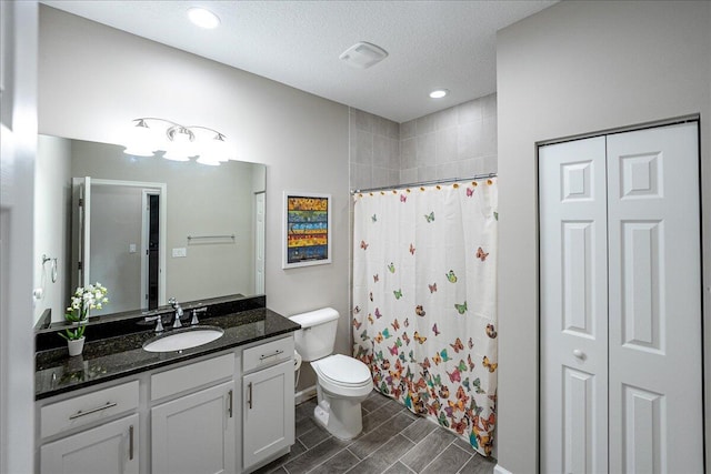 bathroom featuring toilet, a shower with curtain, vanity, and a textured ceiling