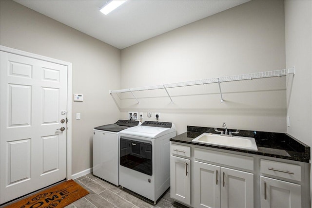 laundry area with independent washer and dryer, cabinets, and sink